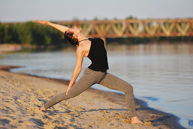 Mooi meisje bezig met yoga op het strand in het voorjaar