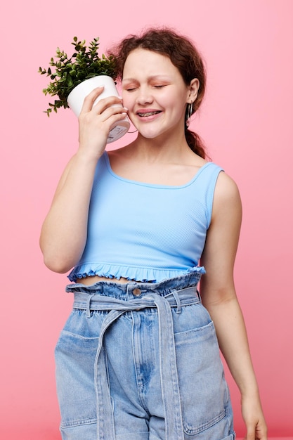 Mooi meisje bloem in witte pot poseren emotie bijgesneden weergave ongewijzigd