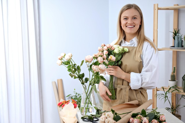 Mooi meisje bloemenhandelaar met bloemen en laptop