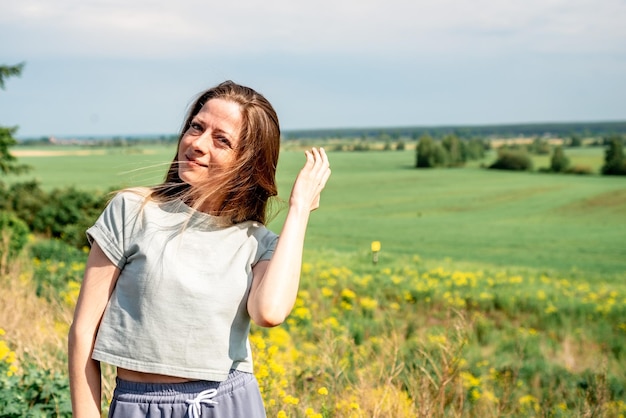 Mooi meisje buiten genieten van de natuur in een zomerveld close-up levensstijl portret het concept van eenheid met de natuur