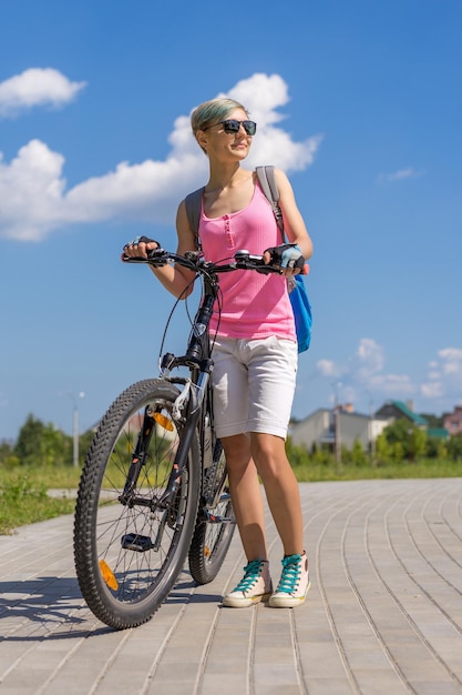 Foto mooi meisje dat bij de fiets zit.