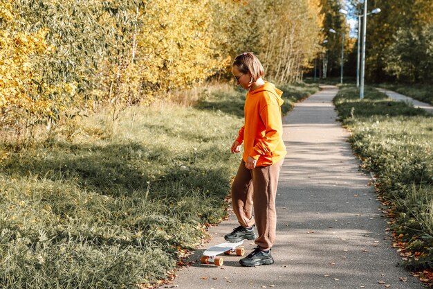 Mooi meisje dat buiten leert skateboarden op een mooie herfstdag