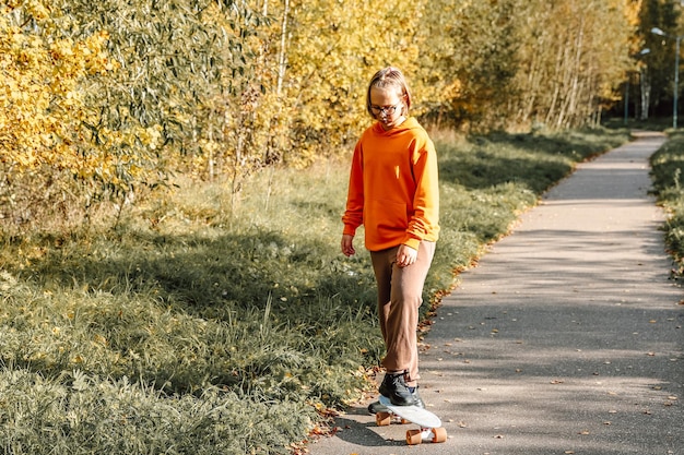 Mooi meisje dat buiten leert skateboarden op een mooie herfstdag