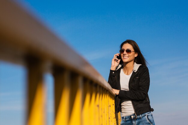 Mooi meisje dat de telefoon in openlucht overneemt