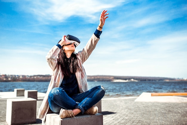 Mooi meisje dat openlucht van virtuele werkelijkheidsglazen geniet