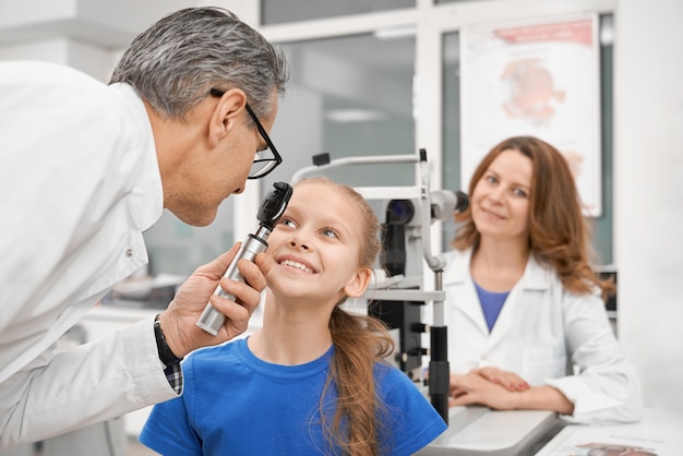 Mooi meisje dat visie in moderne kliniek controleert