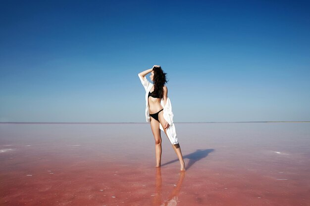 Mooi meisje dat zich in het water op een roze zoutmeer bevindt