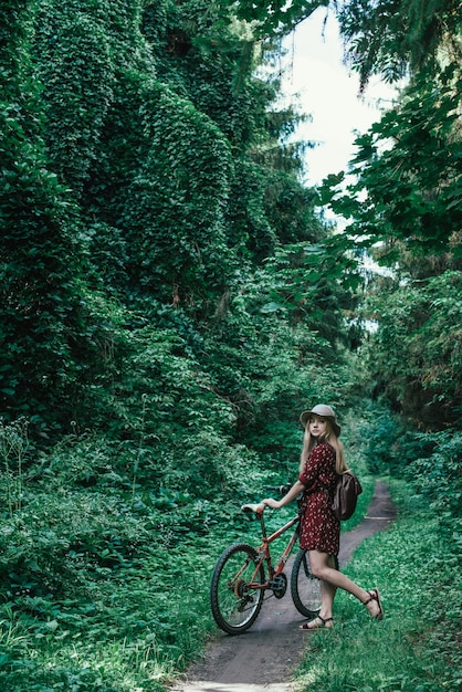 Mooi meisje die een fiets berijden door de levensstijl van de parkaard