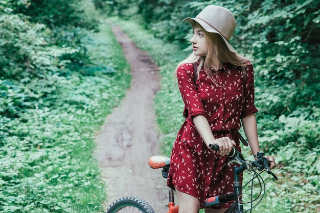 Mooi meisje die een fiets berijden door de levensstijl van de parkaard