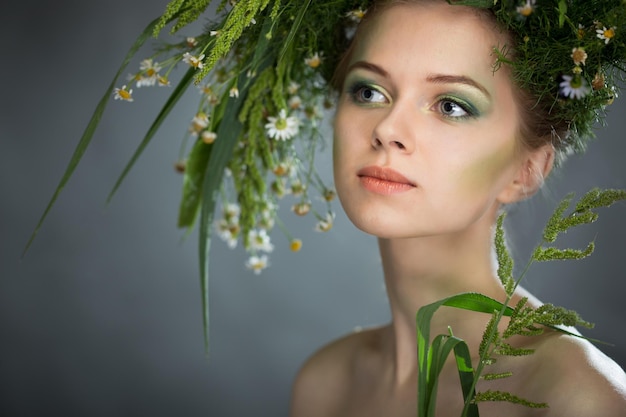 Mooi meisje draagt een krans van wilde bloemen