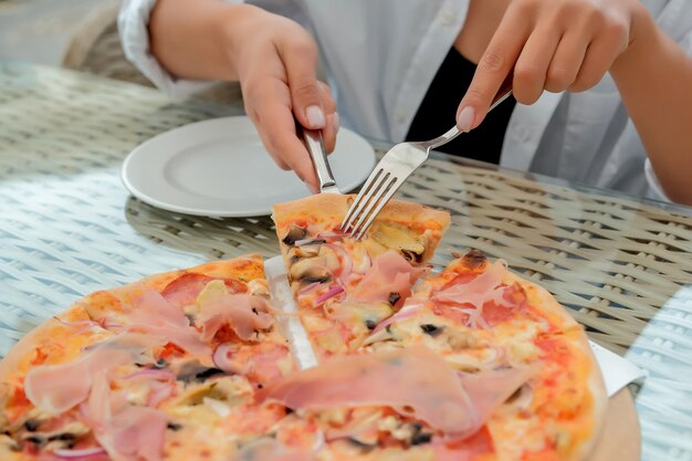 Mooi meisje eet pizza in een straatcafé meisje toont verschillende emoties