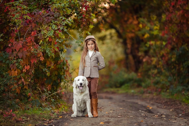 Mooi meisje en een retriever als huisdier voor een wandeling in het herfstpark