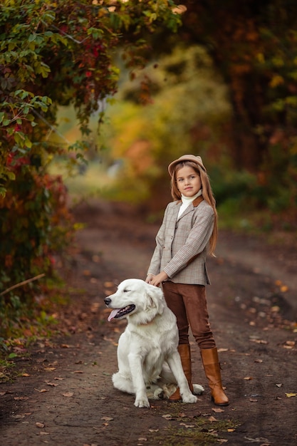 Mooi meisje en een retriever als huisdier voor een wandeling in het herfstpark