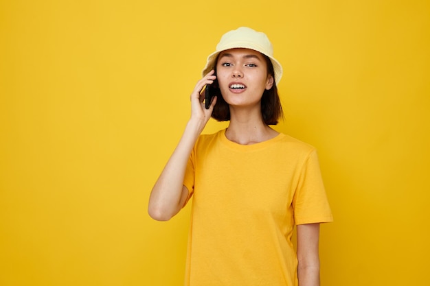 Mooi meisje gele t-shirt en hoed zomerstijl met telefoon Lifestyle ongewijzigd