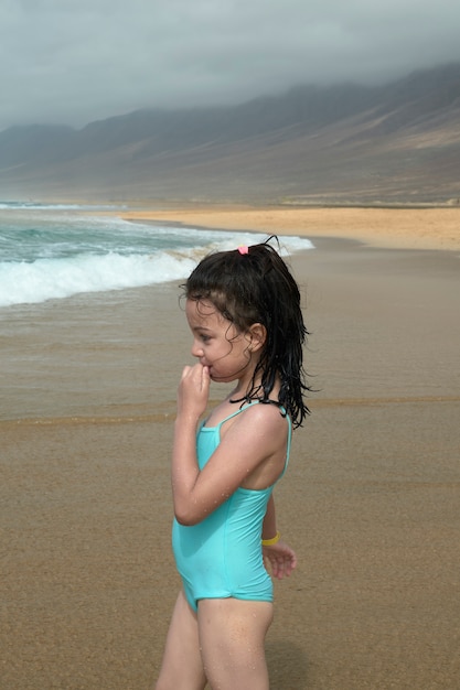 Mooi meisje glimlachend tijdens het spelen op de oever van het strand