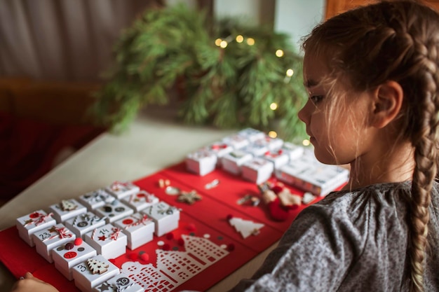 Mooi meisje heeft een originele adventskalender gemaakt van juwelendoosjes en kerst-knutselwerkjes