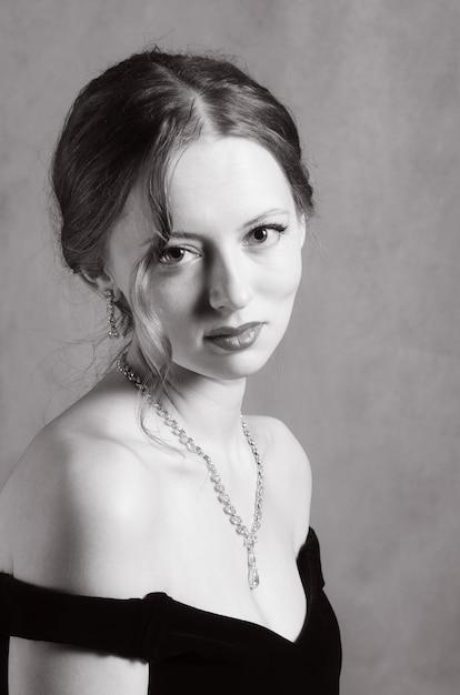 Foto mooi meisje in avondjurk met halslijn. zwart-wit portret in retrostijl