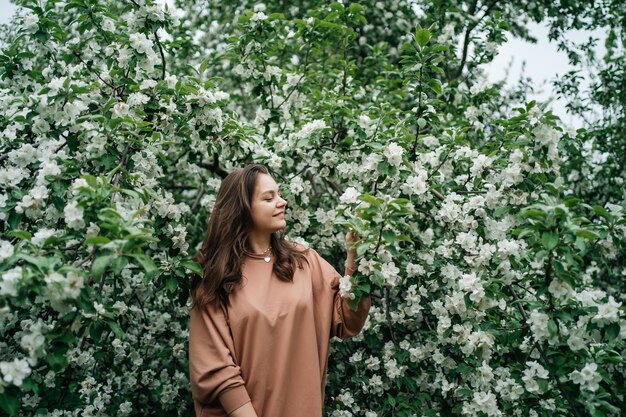 mooi meisje in bloeiende appelboom geur van bloemen buiten natuur