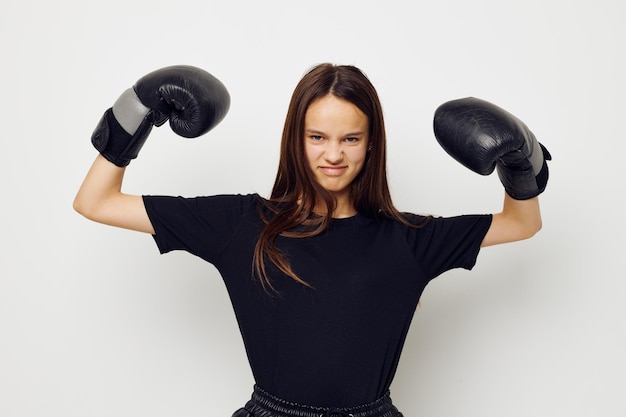 Mooi meisje in bokshandschoenen punch in zwarte broek en een t-shirt fitnesstraining