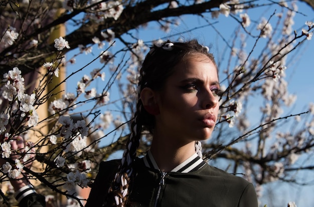 Mooi meisje in de lentepark met bloemen