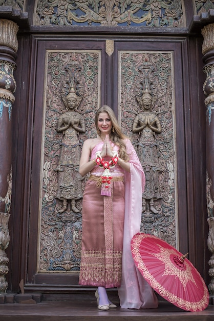 Mooi meisje in de Thaise nationale lichte jurk met oosterse make-up reizen in Thailand