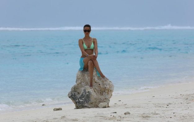 mooi meisje in een bikini aan de kust op het eiland