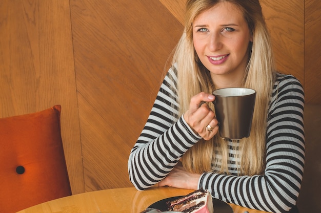 Mooi meisje in een café, genietend van een hete thee. Hipster meisje met hete thee. Verfrissend drankje op zonnige dag.