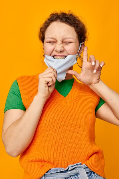 Mooi meisje in een gele t-shirt medische maskerbescherming bijgesneden weergave ongewijzigd