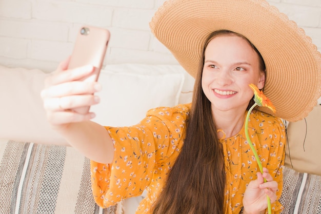 Mooi meisje in een jurk maakt een selfie in de zomer