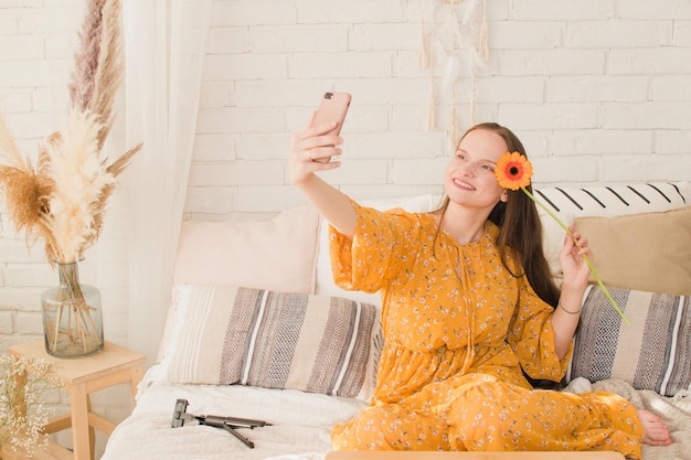 Mooi meisje in een jurk maakt een selfie in de zomer