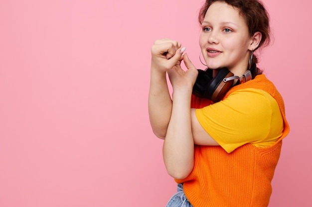 Mooi meisje in een oranje trui koptelefoon muziek entertainment bijgesneden weergave ongewijzigd