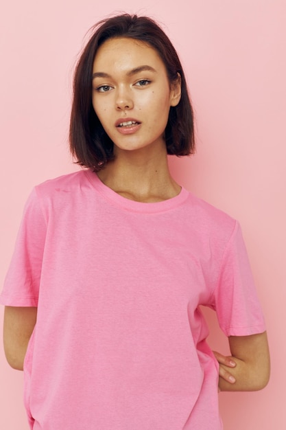 Mooi meisje in een roze T-shirt Jeugdstijl roze achtergrond