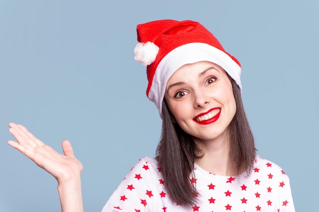 mooi meisje in een t-shirt met een ster en een kerstmanhoed met rode lippenstift op haar lippen