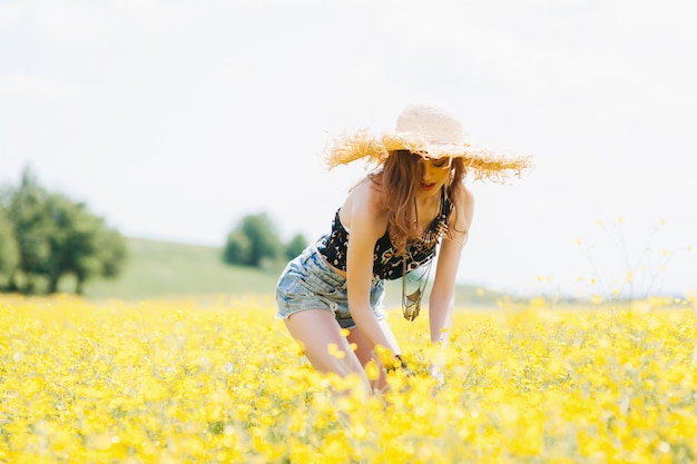 mooi meisje in een veld van gele bloemen