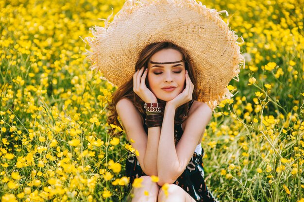 mooi meisje in een veld van gele bloemen