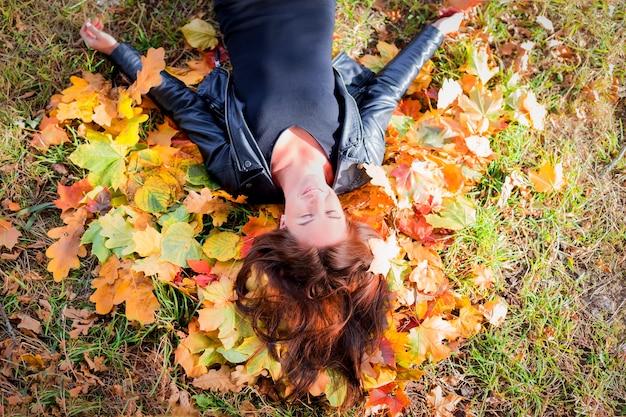 Mooi meisje in herfstbladeren