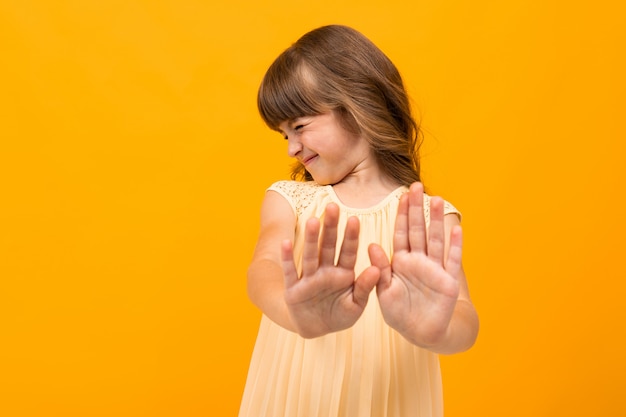 Mooi meisje in jurk geïsoleerd op geel of oranje