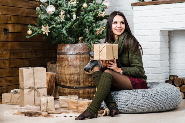 Mooi meisje in Kerstmis ingerichte kamer met geschenkdoos