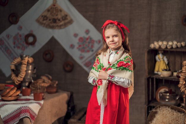 Mooi meisje in kleurrijke sjaal in traditioneel huis