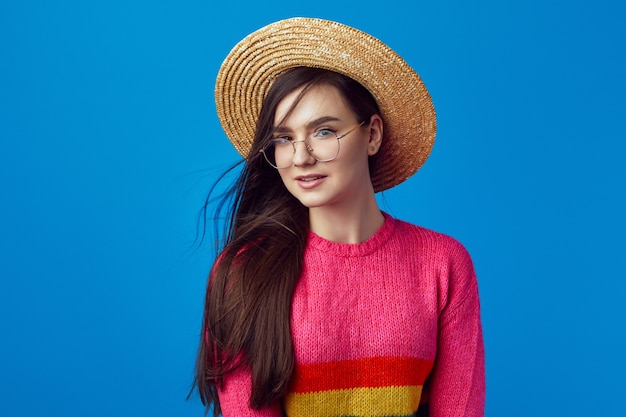 Mooi meisje in regenboogtrui brillen en strohoed poseren schattig