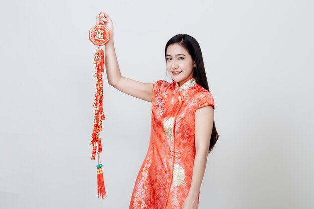 Mooi meisje in rode cheongsam die voetzoekers houden