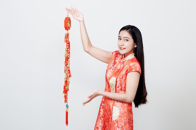 Mooi meisje in rode cheongsam die voetzoekers houden