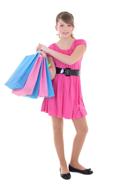 mooi meisje in roze jurk poseren boodschappentassen