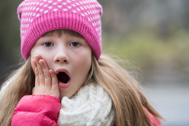 Mooi meisje in warme gebreide winterkleren buitenshuis