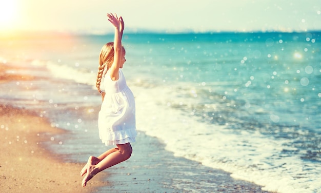 Mooi meisje in witte jurk op strand