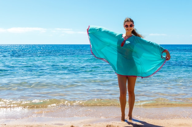 Mooi meisje in zee-stijl met plezier op een strand. Reis- en vakantieconcept