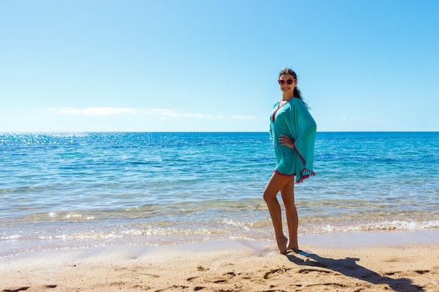 Mooi meisje in zee-stijl met plezier op een strand.