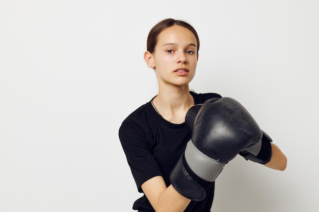 Mooi meisje in zwarte sportuniform bokshandschoenen poseren Ongewijzigde levensstijl