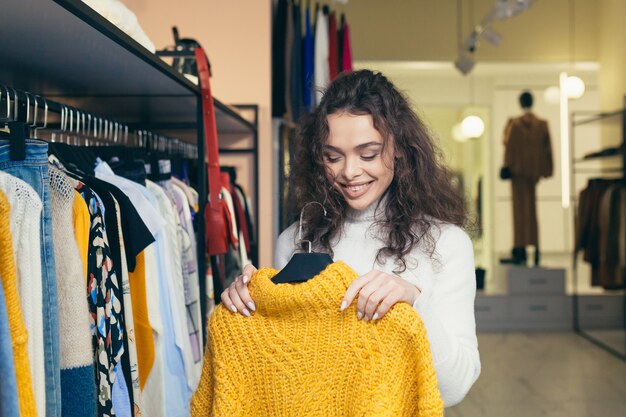 Mooi meisje kiest kleding in een boetiek