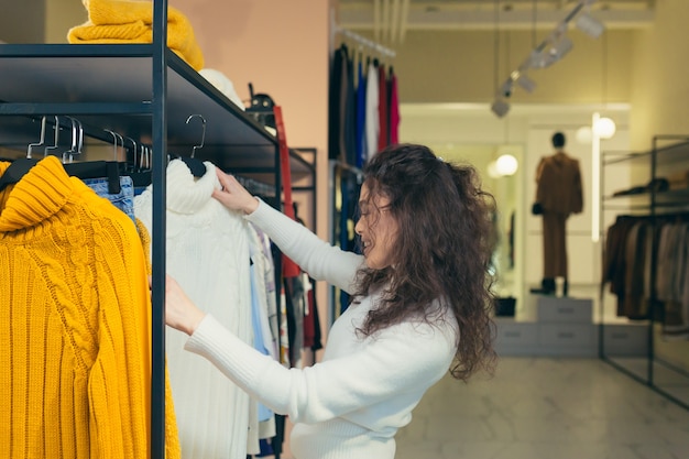 Mooi meisje koper, mooie stijlvolle kleding in een boetiek passen en kopen